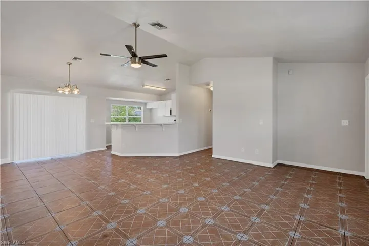 Open concept living space with patterned tile flooring, vaulted ceiling, and recessed lighting