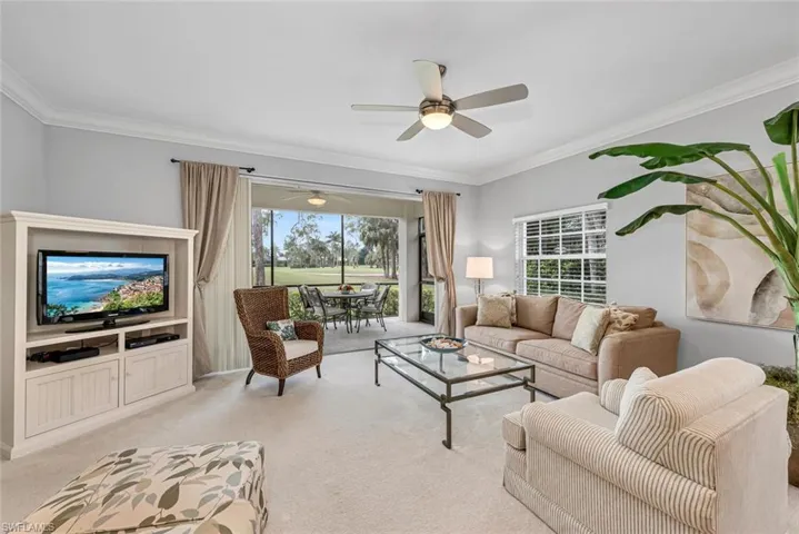 Living room with plenty of natural light, light carpet, crown molding, and ceiling fan