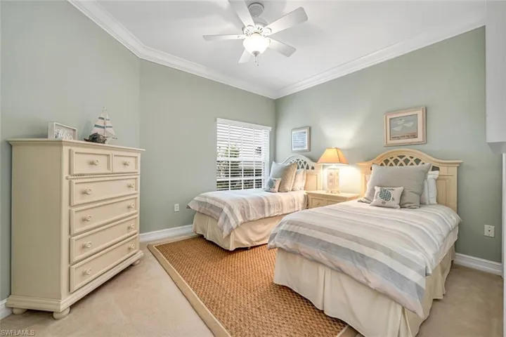 Bedroom with baseboards, ornamental molding, and light carpet