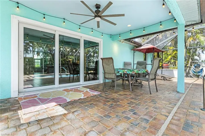 View of patio with ceiling fan and glass enclosure