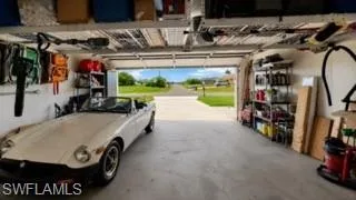 Spacious garage featuring a concrete floor, overhead storage racks, a garage door, and built-in shelving