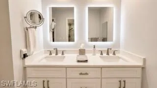Dual vanity with undermount sinks, flanked by two illuminated mirrors