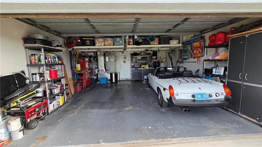 Spacious garage featuring a concrete floor, overhead storage, and built-in cabinetry