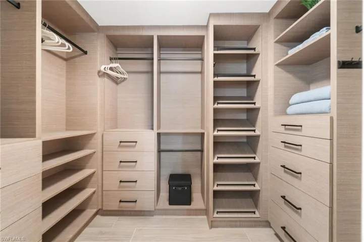 Expansive custom closet with ample drawer space and slanted shoe storage