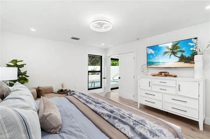 Primary bedroom with pool view and double entry doors