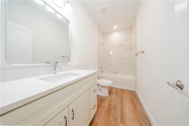 Bathroom featuring vanity, light wood finished floors, and  shower combination
