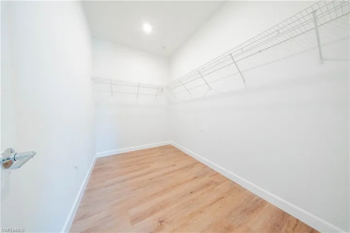 Walk in closet with light wood-style flooring