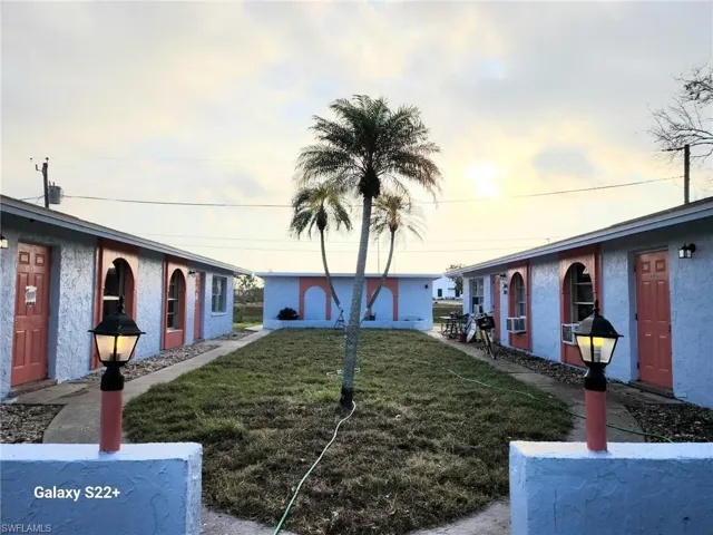 View of front facade with a front yard and stucco siding