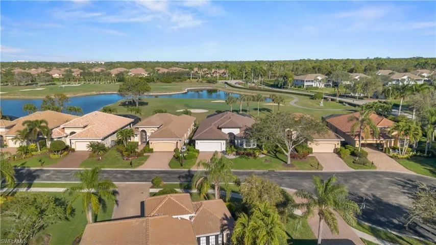 Aerial view of residential area with a nearby body of water and a golf club