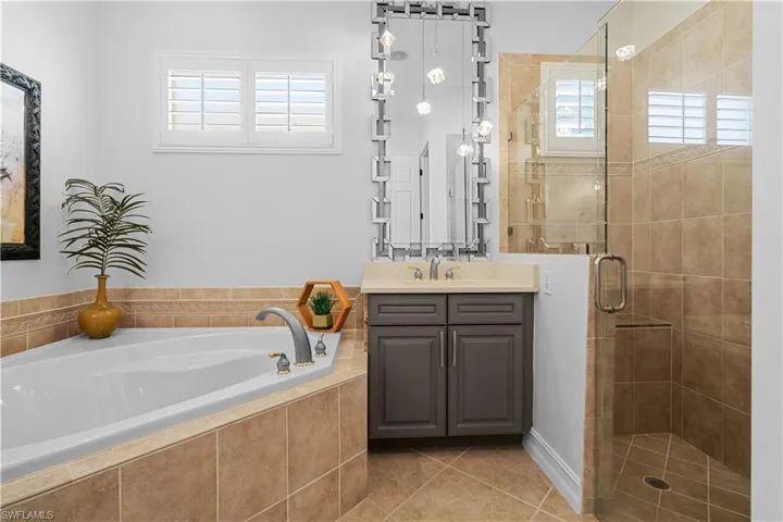 Full bathroom featuring a shower stall, a bath, vanity, and plenty of natural light