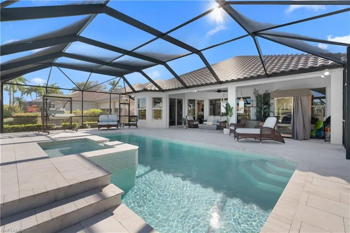View of swimming pool with a patio area, a lanai, outdoor lounge area, a sunroom, and a pool with connected hot tub