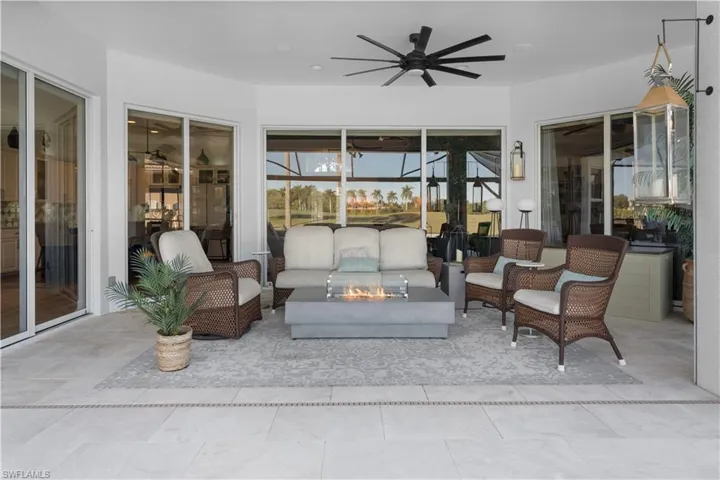 Sunroom with a patio area, an outdoor living space with a fire pit, and a ceiling fan