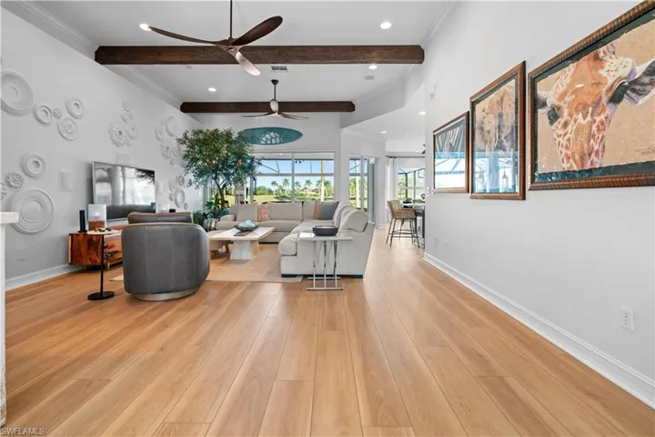 Living room with beamed ceiling, ornamental molding, light wood finished floors, recessed lighting, and a ceiling fan
