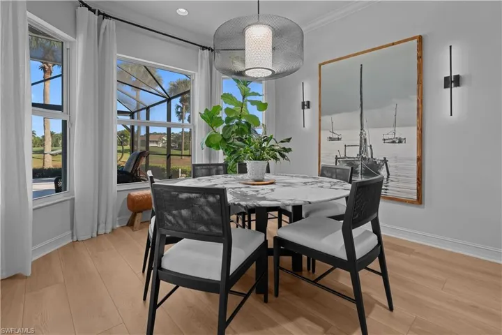 Dining area featuring light wood-style flooring and ornamental molding
