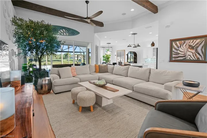 Living area with beam ceiling, recessed lighting, wood finished floors, a ceiling fan, and crown molding