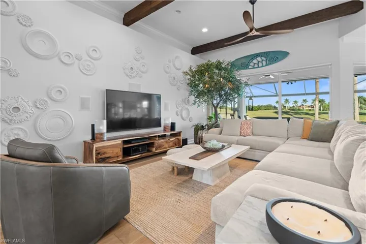 Living room featuring wood finished floors, beam ceiling, ornamental molding, ceiling fan, and recessed lighting