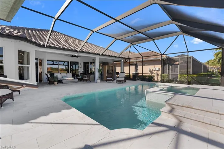 View of swimming pool featuring a patio area, a sunroom, outdoor lounge area, and glass enclosure