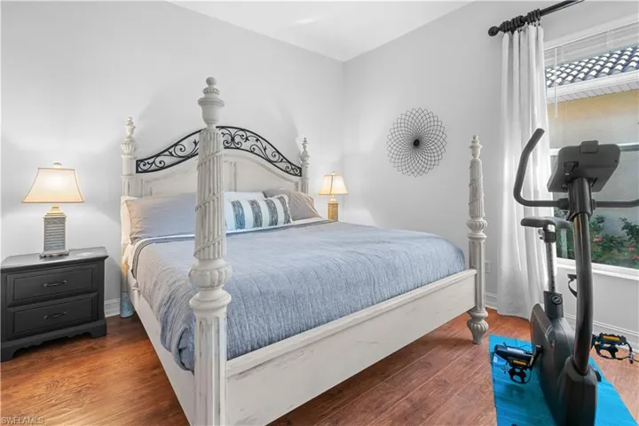Bedroom with hardwood / wood-style floors and baseboards