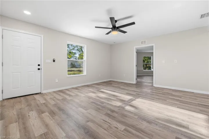 Unfurnished room with ceiling fan, plenty of natural light, and light hardwood / wood-style flooring