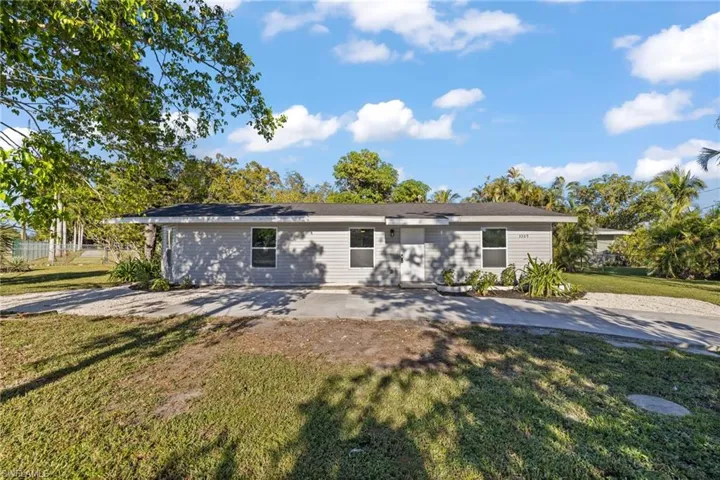 View of front of home with a patio area and a front lawn