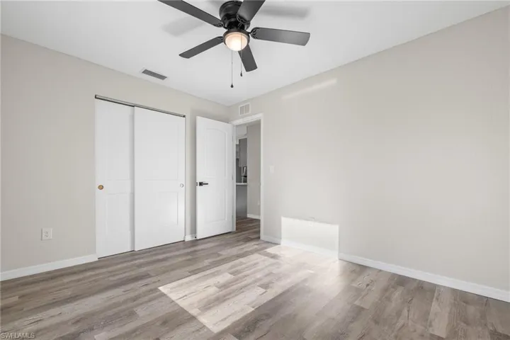 Unfurnished bedroom with ceiling fan, light hardwood / wood-style flooring, and a closet