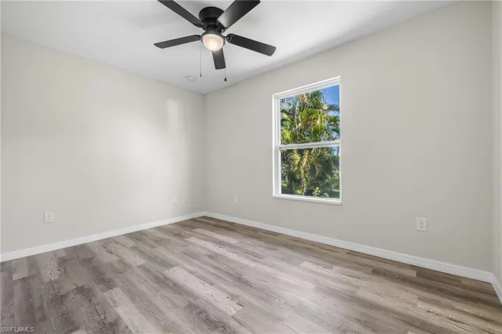 Empty room with ceiling fan and light hardwood / wood-style floors