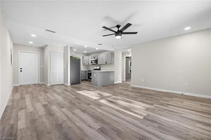 Unfurnished living room with ceiling fan and light wood-type flooring