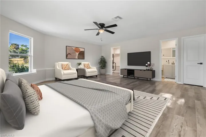 Bedroom with wood-type flooring, connected bathroom, and ceiling fan