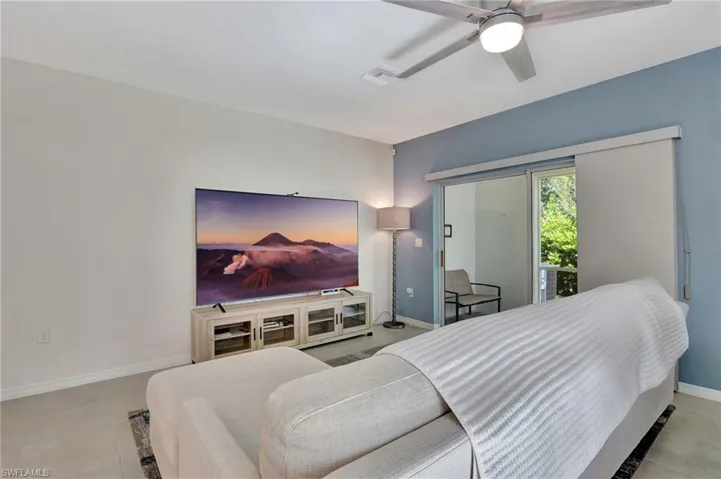 Bedroom featuring light tile patterned floors, ceiling fan, and access to outside