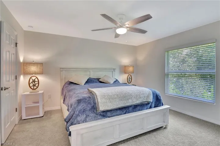 Bedroom featuring light colored carpet and a ceiling fan