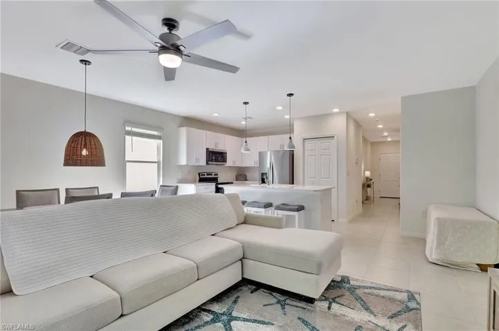 Living room featuring recessed lighting, light tile patterned floors, and ceiling fan