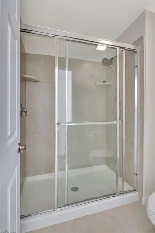 Full bathroom featuring a stall shower and tile patterned flooring