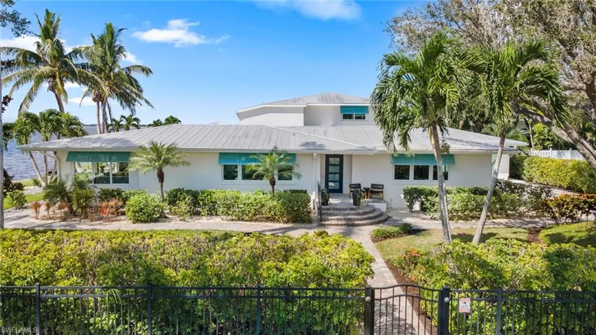 View of front facade featuring a fenced front yard, a metal roof, a gate, and stucco siding