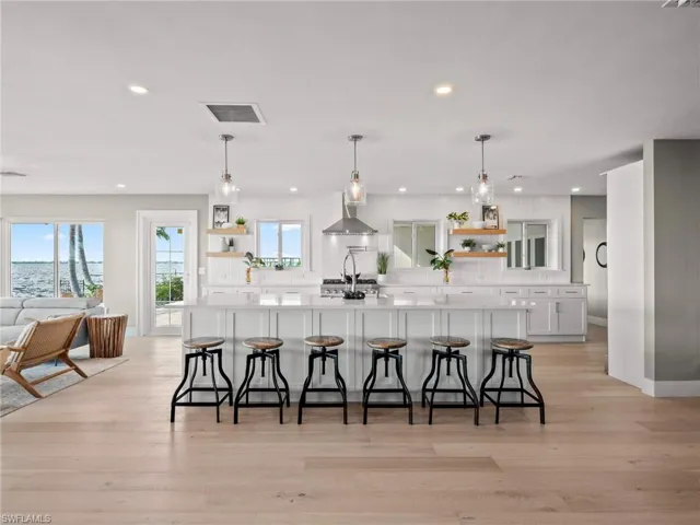 Kitchen featuring open shelves, a kitchen breakfast bar, white cabinetry, and recessed lighting