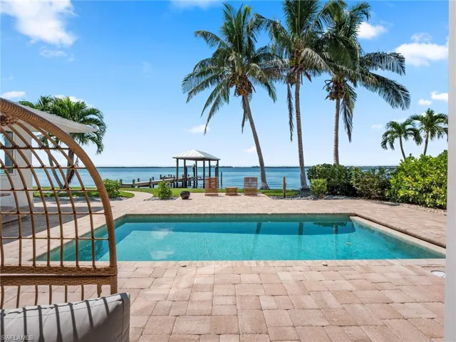 Outdoor pool with a gazebo, a patio, and a water view