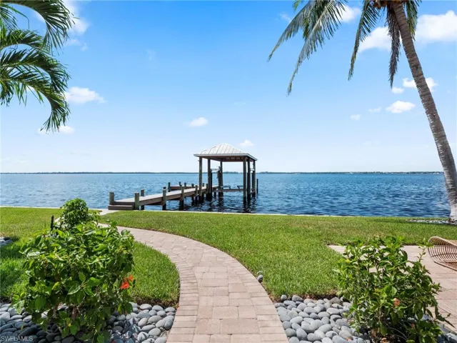 Dock area featuring a water view, a yard, and boat lift