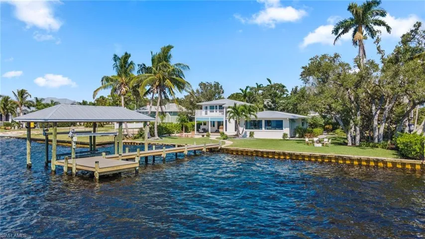 Dock with a water view, a yard, a balcony, and boat lift