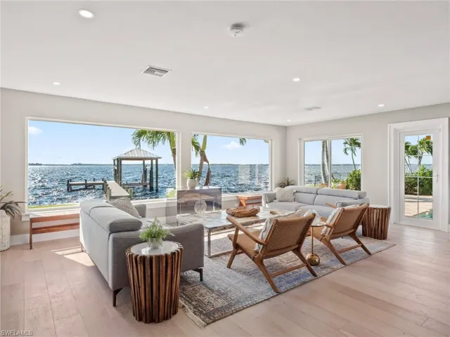 Living area with a water view, light wood-type flooring, and recessed lighting