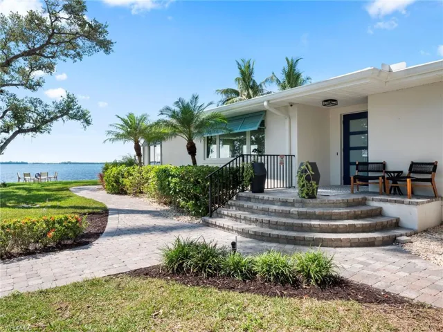Entrance to property with stucco siding, a water view, and a porch