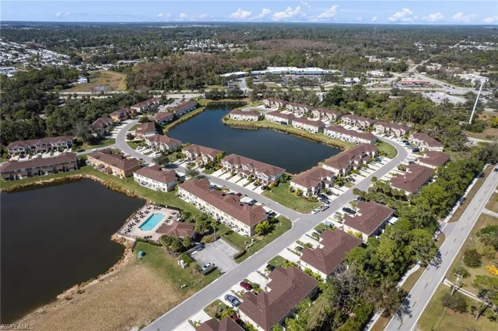 Aerial view of property's location with a nearby body of water and nearby suburban area