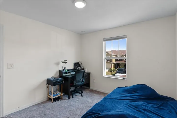 Bedroom featuring carpet and an office area