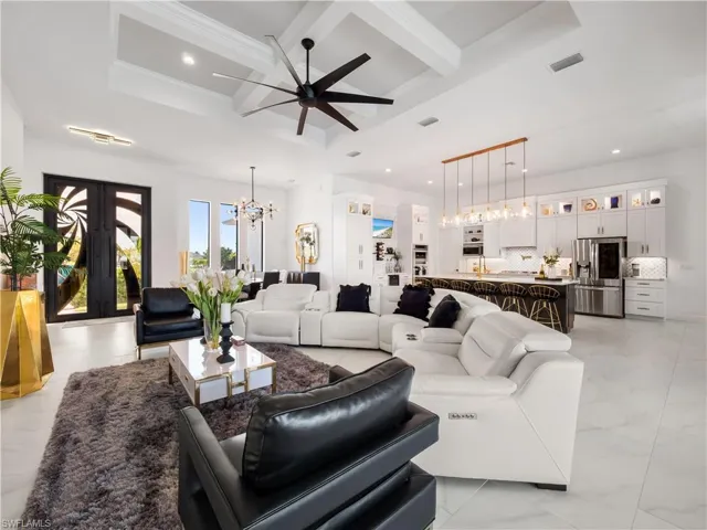 Living area featuring suspended lighting, coffered ceiling, french doors, and ceiling fan