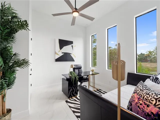 Bedroom with a desk, light marble finish flooring, and ceiling fan
