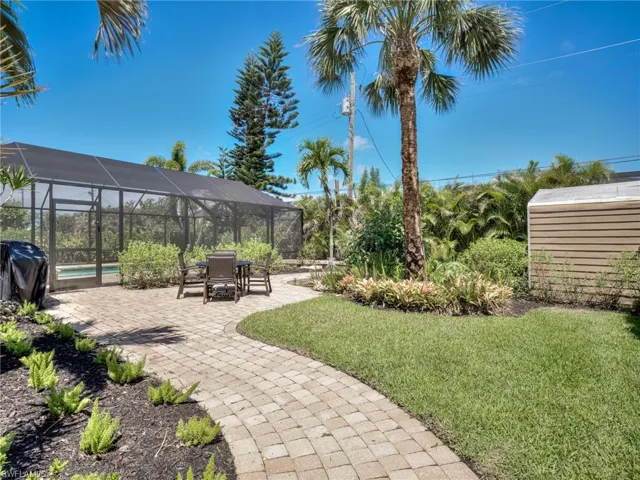 Screened pool enclosure featuring a concrete paver patio