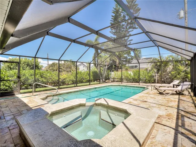Screened lanai featuring a swimming pool and integrated spa