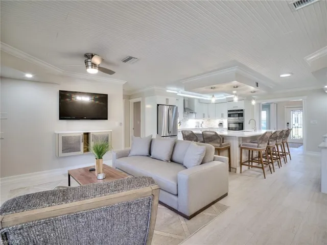 Open-concept living area with plank-style flooring and a beadboard ceiling