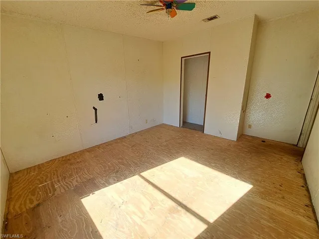 Unfurnished bedroom with a textured ceiling, a ceiling fan, and a closet