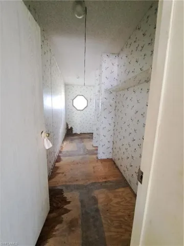 Hall with wallpapered walls and a textured ceiling