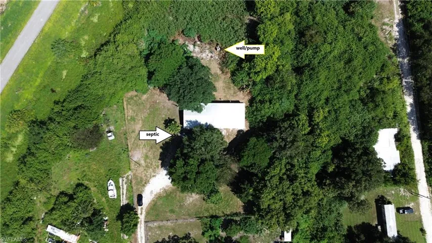 Aerial view of property and surrounding area with a heavily wooded area