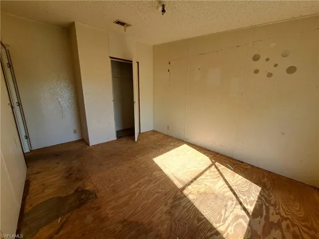Unfurnished bedroom with a textured ceiling and a closet